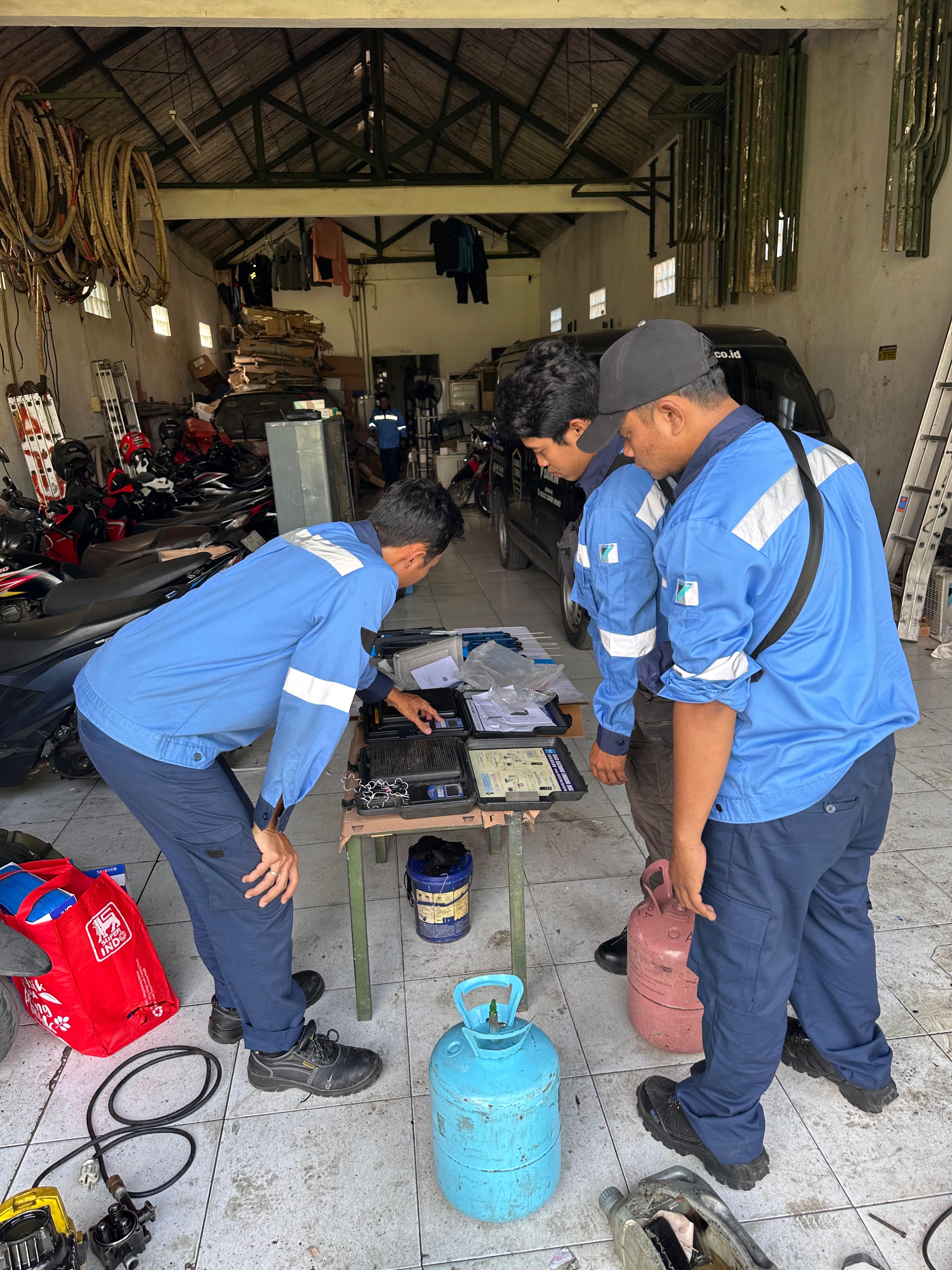Tim teknisi menyiapkan peralatan dan refrigeran